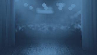 Ein dunkle Bühne mit Blick auf die Zuschauer.